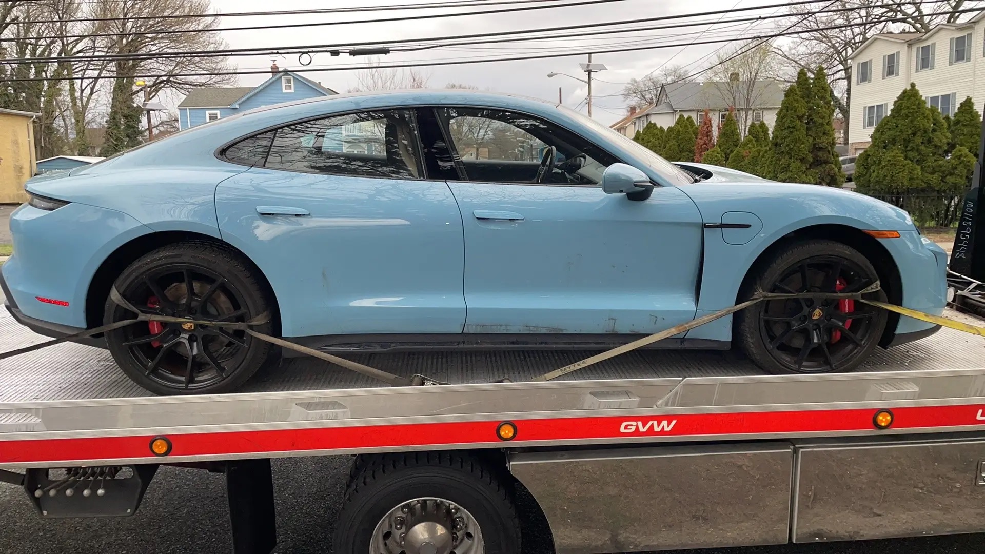 Blue Porsche Taycan being transported on our flatbed tow truck